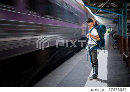 Traveler waits train at train station for travel in summer 77478085