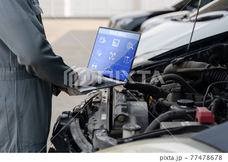 Mechanic using a laptop computer to check collect information during work a car engine. service maintenance of industrial to engine repair. Mechanic using a laptop computer to check collect information during work a car engine. service maintenance of industrial to engine repair. 77478678
