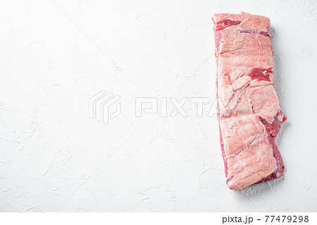 Raw Organic Beef Short Ribs Ready to Cook, on white stone background, with copy space for text 77479298