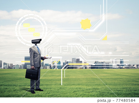 Camera headed man standing on green grass against modern citysca Camera headed man standing on green grass against modern citysca 77480584
