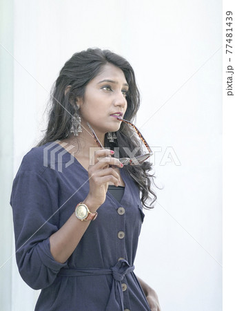Portrait of a beautiful Indian woman fashion model holding sunglasses with her hand. Portrait of a beautiful Indian woman fashion model holding sunglasses with her hand. 77481439