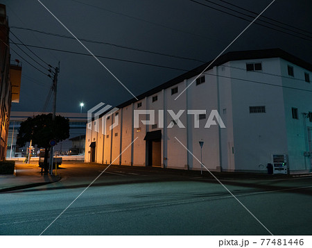 ライトに照らされた夜の港の倉庫 77481446