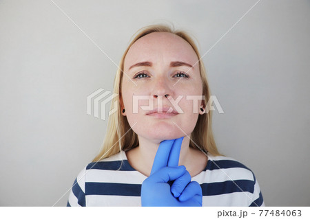 The doctor examines and feels the lymph nodes of the patient, who complains of pain and sore throat. The concept of medical care and diagnosis of coronavirus or influenza 77484063