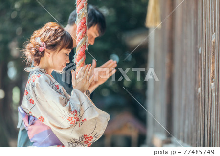 お参りする浴衣姿の男女 77485749