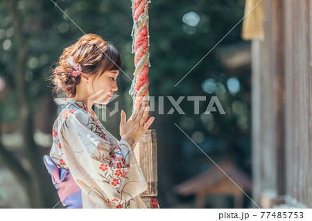 お参りする浴衣姿の女性 77485753