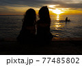 my daughter are watching the sunset over the sea 77485802