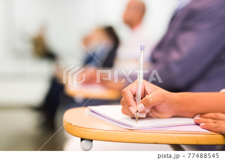 Closeup of female hand taking notes during lecture Closeup of female hand taking notes during lecture 77488545
