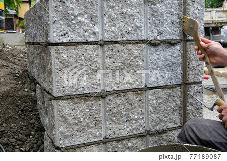 新築一戸建ての外構工事現場でブロックを積む作業をしているところ 77489087