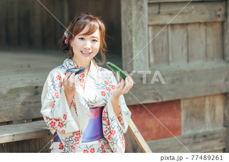 お盆のお供物を持つ浴衣姿の女性 77489261