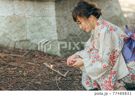 花火をする浴衣姿の女性 77489831