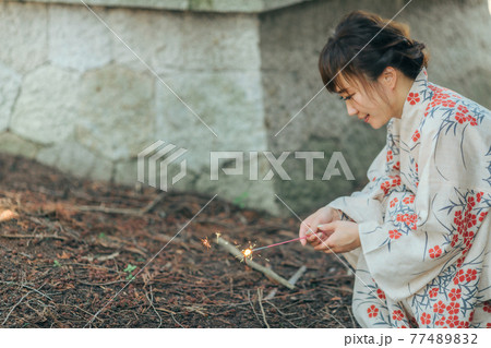 花火をする浴衣姿の女性 77489832