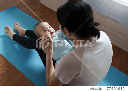 Asian mother in sportswear playing with her baby boy son Asian mother in sportswear playing with her baby boy son 77491032