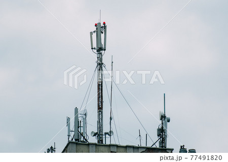 Mobile antennas are located on the roof of the house. Mobile antennas are located on the roof of the house. 77491820