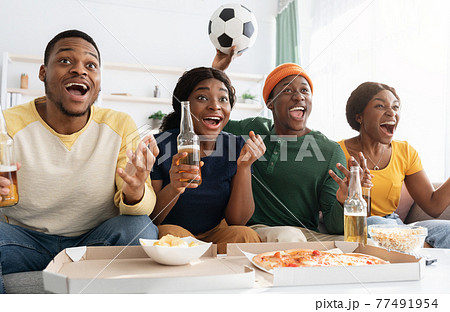 Emotional african american friends watching football match together 77491954
