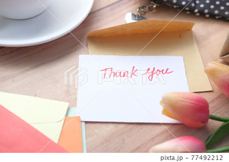 thank you message, flower and envelope on wooden table  77492212