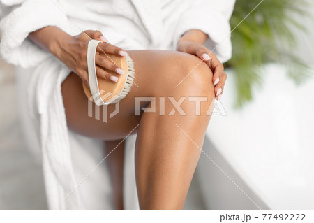 Unrecognizable African Woman Dry Brushing Legs Making Massage In Bathroom Unrecognizable African Woman Dry Brushing Legs Making Massage In Bathroom 77492222