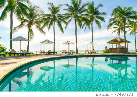 Beautiful umbrella and chair around swimming pool in hotel and resort 77497273