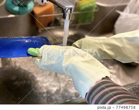 ゴム手袋をしてフライパンを洗う手元 77498758