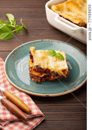 Traditional Italian lasagna on plate on wooden table Traditional Italian lasagna on plate on wooden table 77499850