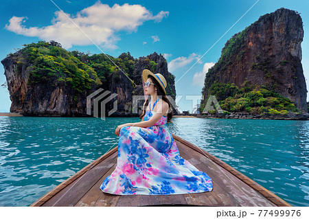 Beautiful girl sitting on the boat at James Bond island in Phang nga, Thailand. Beautiful girl sitting on the boat at James Bond island in Phang nga, Thailand. 77499976