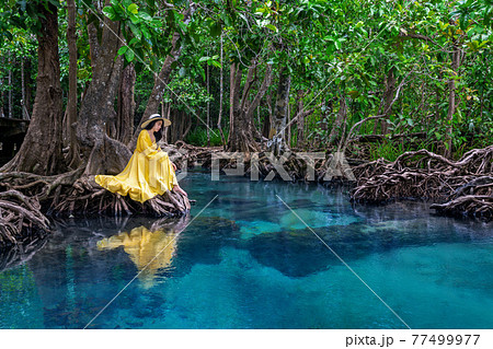Woman sitting on Tapom in Krabi, Thailand. 77499977