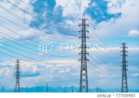 立ち並ぶ送電鉄塔と空に浮かぶ雲 遠い山並み 鮮やか 立ち並ぶ送電鉄塔と空に浮かぶ雲 遠い山並み 鮮やか 77500965