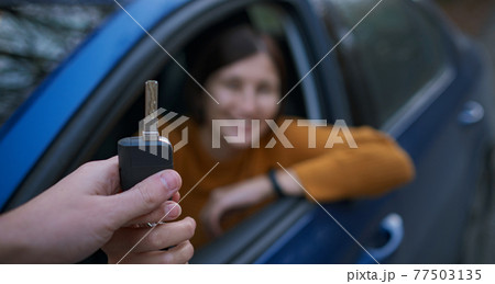Auto Dealer Giving asian Woman Automobile Key For Test Drive. 77503135