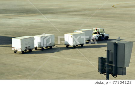 Staff carry luggage along the airport lane Staff carry luggage along the airport lane 77504122