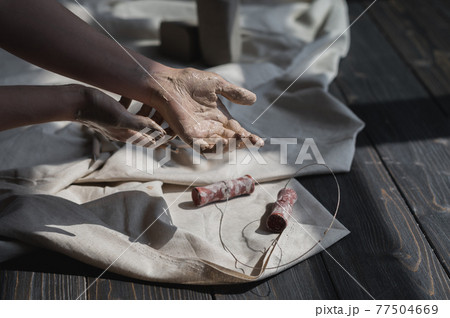 Close up picture of female ceramic artist arms in clay after making pottery. Close up picture of female ceramic artist arms in clay after making pottery. 77504669