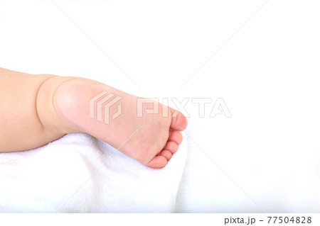白シーツを背景にした新生児の片足のアップの写真素材