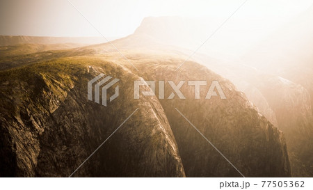 dry yellow grass on the rocky mountain with heavy fog 77505362