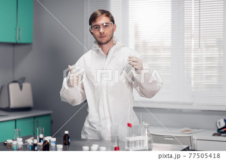 A young male scientist testing a Chemical in a science Laboratory. The scientistific analysis of chemicals for New Innovation. Science Laboratory Concept 77505418