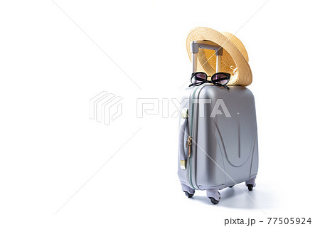 Tropical background. Suitcase, sunglasses with palm leaves and straw hat in travel composition isolated on white background. Exotic tropical beach with copy space. Tropical background. Suitcase, sunglasses with palm leaves and straw hat in travel composition isolated on white background. Exotic tropical beach with copy space. 77505924