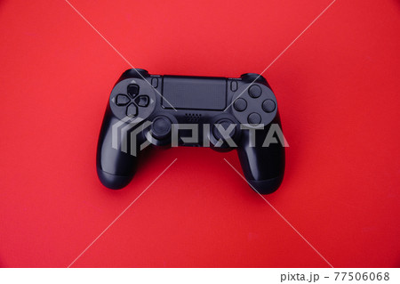 Black gamepad isolated on a red background. Top view. Gaming concept 77506068