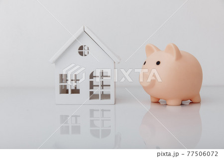 Piggy bank and house model. Banking concept Piggy bank and house model. Banking concept 77506072