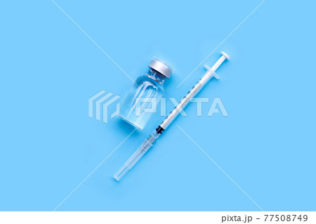 Bottle of vaccine and syringe on blue background with copy space. Covid-19 Coronavirus concept 77508749