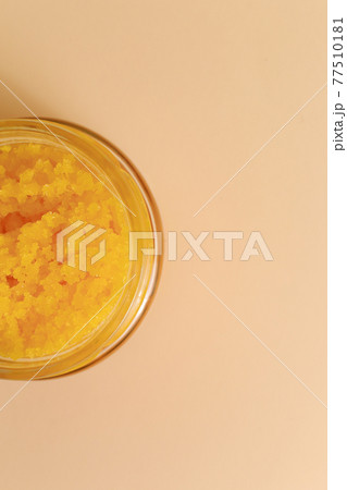 Body scrub of sea salt with lemon, rosemary and olive oil in glass jar on stone table, homemade cosmetic for Spa care 77510181
