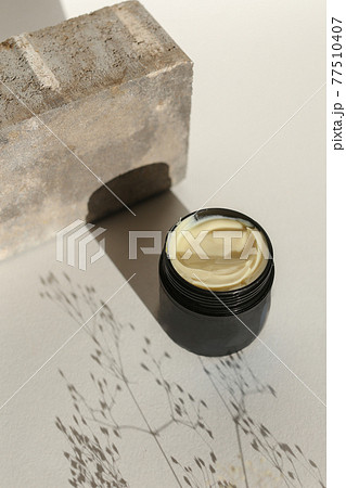 Cosmetic cream container with face or body cream on neutral background 77510407