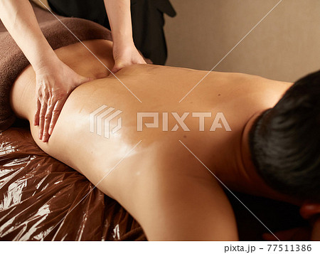腰のマッサージを受けるアジア人男性 77511386