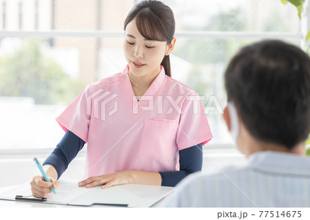 医療　患者から話を聞く看護師（女性） 77514675