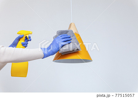 Hands in gloves removing dust, cleaning electric lamp, chandelier Hands in gloves removing dust, cleaning electric lamp, chandelier 77515057