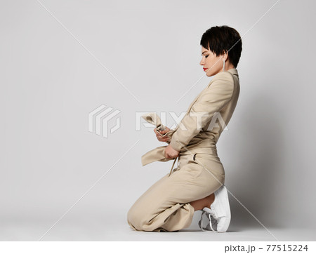 Adult woman in beige business casual pantsuit and Adult woman in beige business casual pantsuit and 77515224