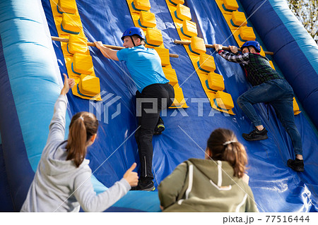 People passing obstacles at amusement park 77516444