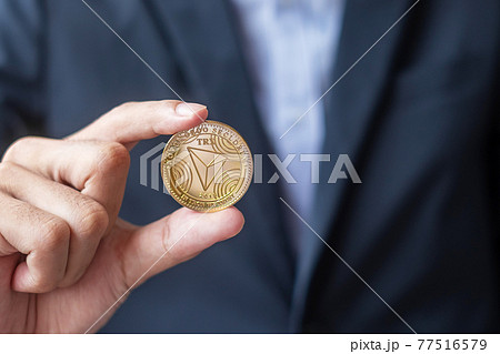 man hand holding gold Tron coin (TRX) cryptocurrency, Crypto is Digital Money within the blockchain network, is exchanged using technology and online exchange. Decentralized Financial concept 77516579