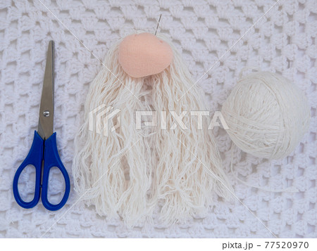 Scandinavian gnome with long beard red hat white knit background step by step handmade tutorial. Homemade DIY Scandinavian gnome with long beard red hat white knit background step by step handmade tutorial. Homemade DIY 77520970