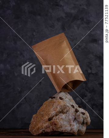 Balancing pouch bag mockup natural stone. Blank kraft paper pack with coffee beans dark background. Equilibrium floating 77521139