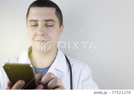 The doctor is holding a smartphone. Medical consultation by phone. Mobile app for healthcare providers 77521179