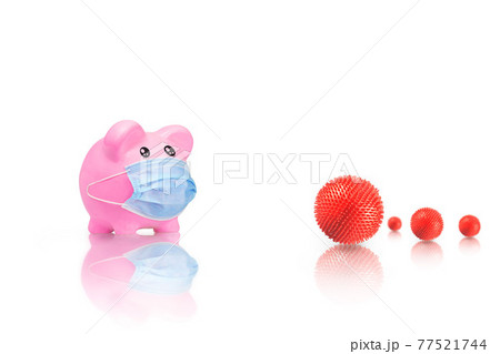 Piggy bank in medical mask with virus strain model on white background. Covid-19 pandemic. Financial difficulties due to Covid-19. Piggy bank running out of money due to coronavirus. Piggy bank in medical mask with virus strain model on white background. Covid-19 pandemic. Financial difficulties due to Covid-19. Piggy bank running out of money due to coronavirus. 77521744