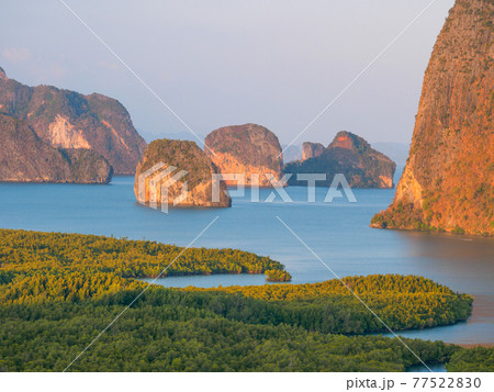 熱帯のジャングルと湾にそびえる岩の小島 (パンガー県、タイ王国) 77522830