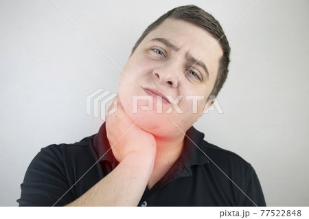 A man touches a sore throat and neck, twists from irritation and inflammation. Sore throat when swallowing, suspected pharyngitis or acid reflux. A man touches a sore throat and neck, twists from irritation and inflammation. Sore throat when swallowing, suspected pharyngitis or acid reflux. 77522848